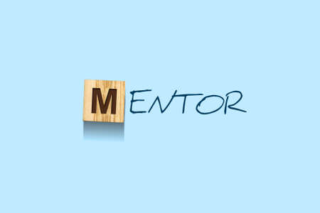 Mentor. Words written on a wooden block. Blue background. Isolated. Business. Leadership conceptの写真素材
