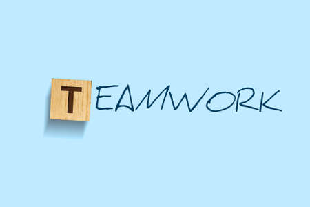 Teamwork. Words written on a wooden block. Blue background. Isolated. Business concept. Teamwork conceptの写真素材