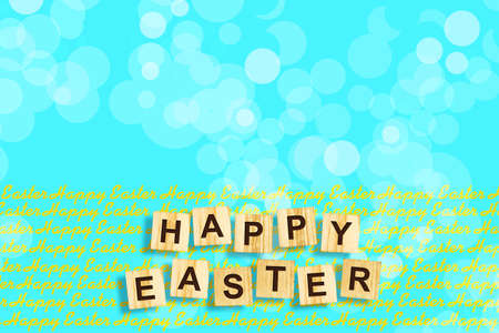 Happy Easter, word written on wooden blocks on blue background. Copy space. Place for text. Easter. Background.の写真素材