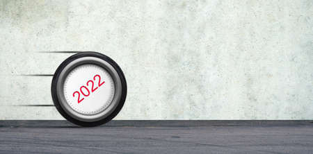 Wheel of a 2022 car is rolling down the road. The concept of the coming New Year 2022. New year...