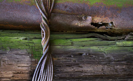 Old tree and rusty pipe held together with wire. Grunge backgroundの写真素材
