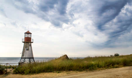Old lighthouse with a cloudy sky by the Black seaの写真素材
