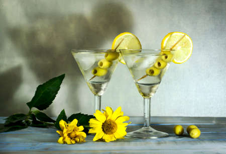 Martini with olives, lemon and ice on the old blue wooden tableの写真素材
