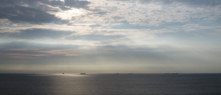 Sunrise Seascape with ships on the horizon and cloudy skyの写真素材