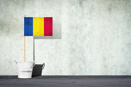 Flag of Romania, on a stick, in a small bucket, against the background of a concrete wall. Copy space. Signs and Symbols.3D illustration. Flags.の写真素材