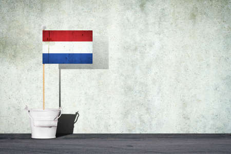 Flag of Netherlands, on a stick, in a small bucket, against the background of a concrete wall. Copy space. Signs and Symbols.3D illustration. Flags.の写真素材