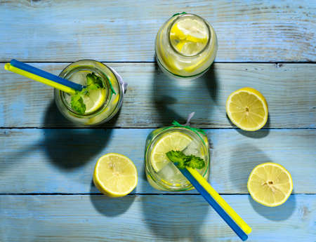 Cold lemonade in bottles with lemons on a blue wooden background. Top viewの写真素材