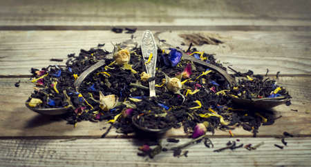 Dry tea in a three spoon on wooden backgroundの写真素材