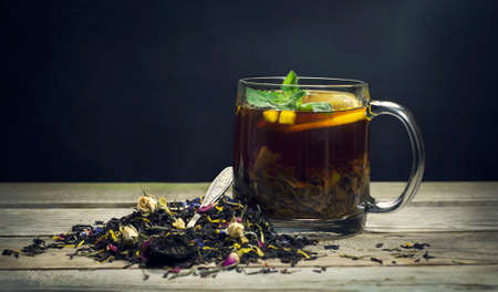 Cup of tea with lemon, mint and spoon on a wooden backgroundの写真素材