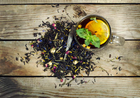 Cup of tea with lemon, mint and spoon on a wooden background. Top viewの写真素材