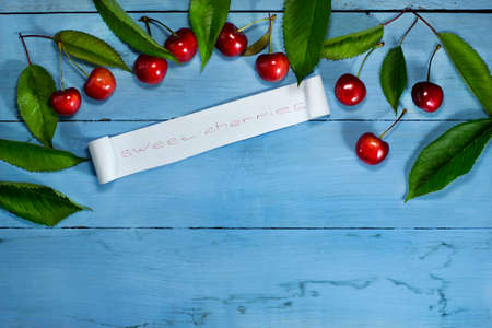 Cherries on a blue wooden background. Top view with copy spaceの写真素材