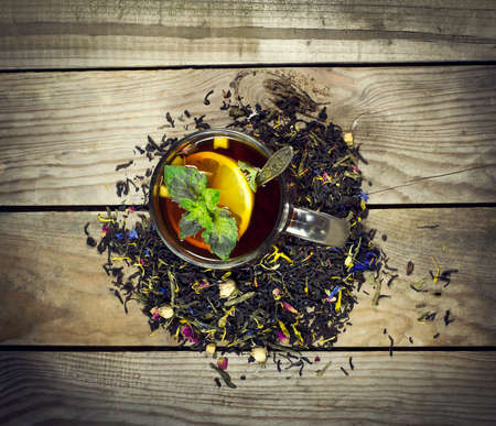 Cup of tea with lemon, mint and spoon on a wooden background. Top viewの写真素材