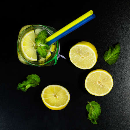 Cold lemonade in bottles with lemons on a black background. Top viewの写真素材