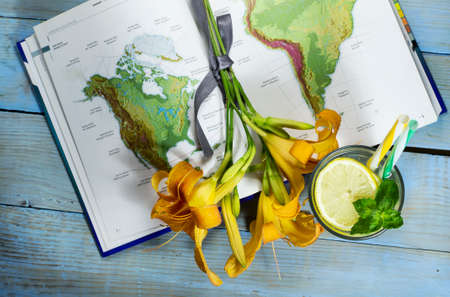 Top view lemonade, flower and geographic map on wooden tableの写真素材