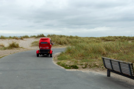 Small electric car drives along the path. Copenhagen beach. Baltic Sea. Modern technologies. Ecological transport. Transport.の写真素材