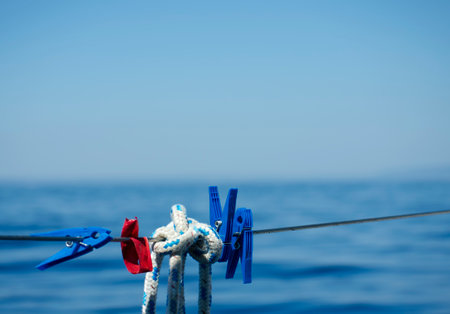 Clothespins and rope on the background of the sea on a sunny dayの写真素材