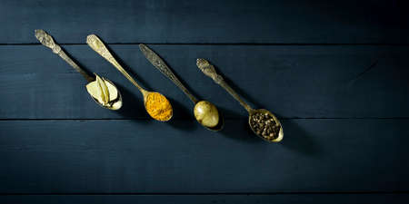 Quail egg in a spoon and spices. On a blue wooden backgroundの写真素材