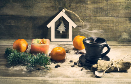 Cup of coffee with beans, mandarin, warm scarf, with pine branches. Winter, New Year, Christmas still life. Wooden backgroundの写真素材