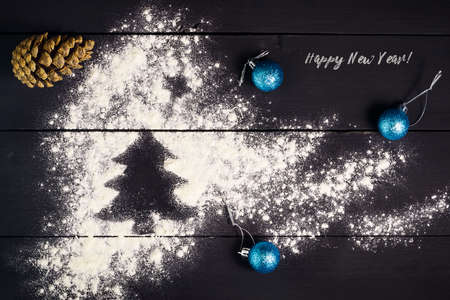 Christmas tree painted with flour on a dark wooden background. New Year, Christmas greeting card. Celebratory background.の写真素材
