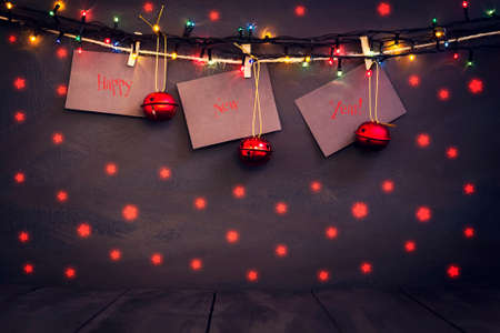 Happy new year on paper with a clothespin, hanging on a rope on a dark wooden background. Greeting card with a happy new year. Holidays. Gifts.の写真素材