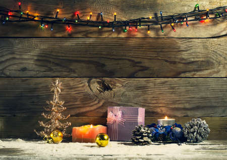 Glowing Christmas tree garland with decorations on a wooden backgroundの写真素材