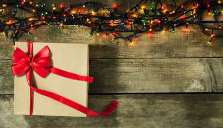 Glowing Christmas tree garland with presents on a wooden backgroundの写真素材