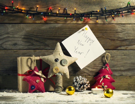 Glowing Christmas tree garland with decorations on a wooden backgroundの写真素材