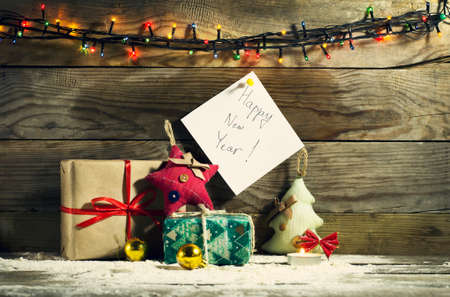 Glowing Christmas tree garland with decorations on a wooden backgroundの写真素材