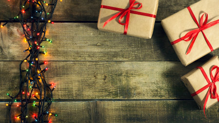 Glowing Christmas tree garland with presents on a wooden backgroundの写真素材