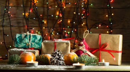 New year composition with tangerines and gifts on the old wooden background with Christmas tree garlandの写真素材