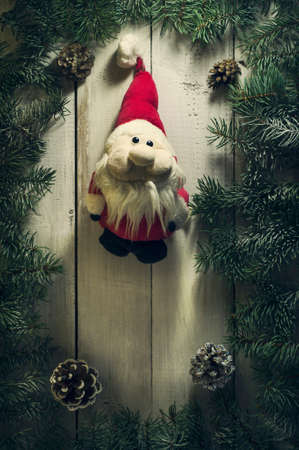 Christmas New year composition with branches of spruce and an old vintage toy Santa Claus on the old wooden background.Top viewの写真素材