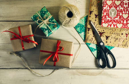 Christmas gifts with wrapping paper on the old wooden background.Top viewの写真素材