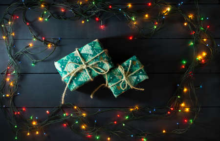 Glowing Christmas tree garland with presents on a blue wooden backgroundの写真素材