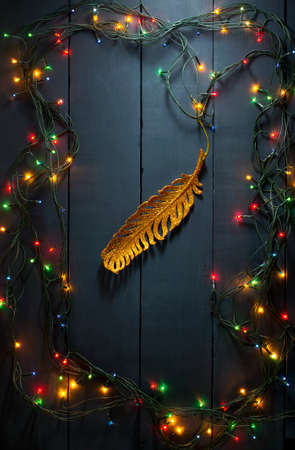 Glowing Christmas tree garland with presents on a blue wooden backgroundの写真素材