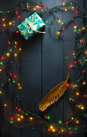 Glowing Christmas tree garland with presents and toys on a blue wooden backgroundの写真素材