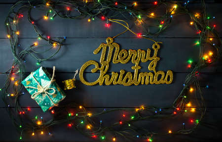Glowing Christmas tree garland with presents and toys on a blue wooden backgroundの写真素材
