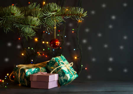 Christmas gifts under a pine tree on a blue wooden backgroundの写真素材