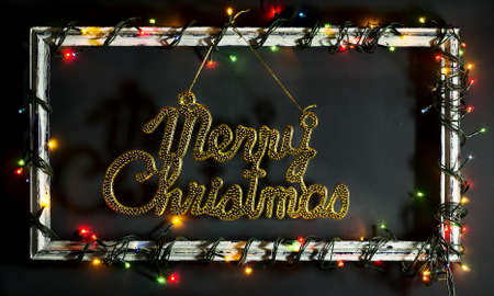 Glowing Christmas tree garland on old frame with decorations and gifts. On a blue wooden background.の写真素材