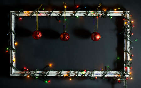Glowing Christmas tree garland on old frame with decorations and gifts. On a blue wooden background.の写真素材
