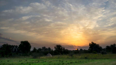 Beautiful sunrise in a field with amazing clouds. Tent. Travels. Tourismの写真素材
