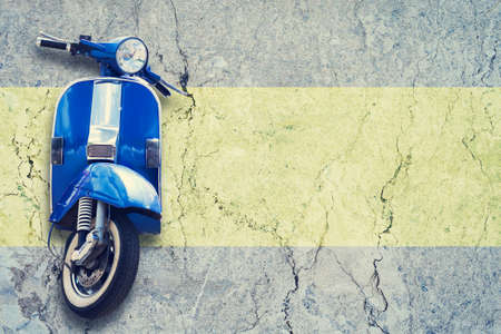 Old vintage blue scooter on concrete wall background. The concept of repair or rental scooters and motorcycle. Copy space.の写真素材