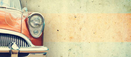 The headlight of the old beautiful car on the background of a concrete wall. Copy space. Concept banners repair, sale of cars. Close-up.の写真素材