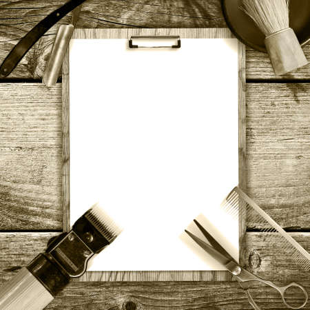 Concept of Barber Shop. Set of hairdressing tools and blank white sheet for text on a wooden background. Copy space. Toned, Sepia Beauty and Fashionの写真素材