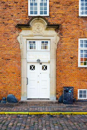 Copenhagen, Denmark - July 9, 2018. Beautiful antique entrance front door against a yellow brick wall. Architecture. Details.のeditorial素材