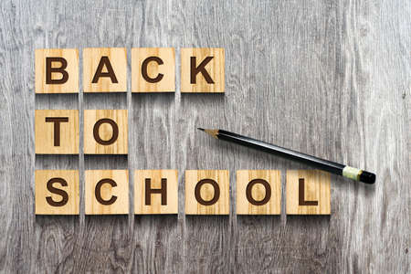Back to school. An inscription from the alphabet on cubes. Gray wooden background. Concept of education.の写真素材