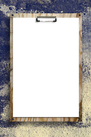 Empty sheet of paper attached to a wooden board, against the background of an old wall. Copy space.の写真素材