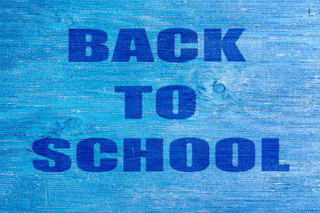 Back to school. The inscription on a blue wooden background. Education. Backgrounds.の写真素材