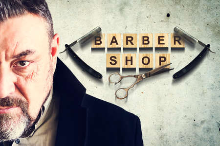 Concept Barber Shop. Bearded man on the background of a concrete wall. Inscription Barber Shop. Beauty and fashion. Background.の写真素材