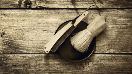 Concept Barber Shop. Old hairdresser's razor and shaving brush on a wooden background. Toned. Sepia. Copy space Beauty. Fashionの写真素材