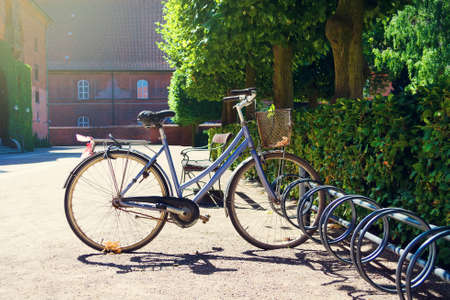 Old bicycle in the parking lot, in a beautiful garden. Summer sunny day. Transpot. Bicycles. Travels.の写真素材
